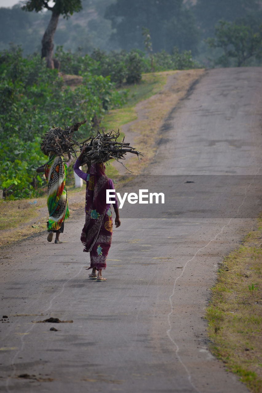 Rear view of women walking on road