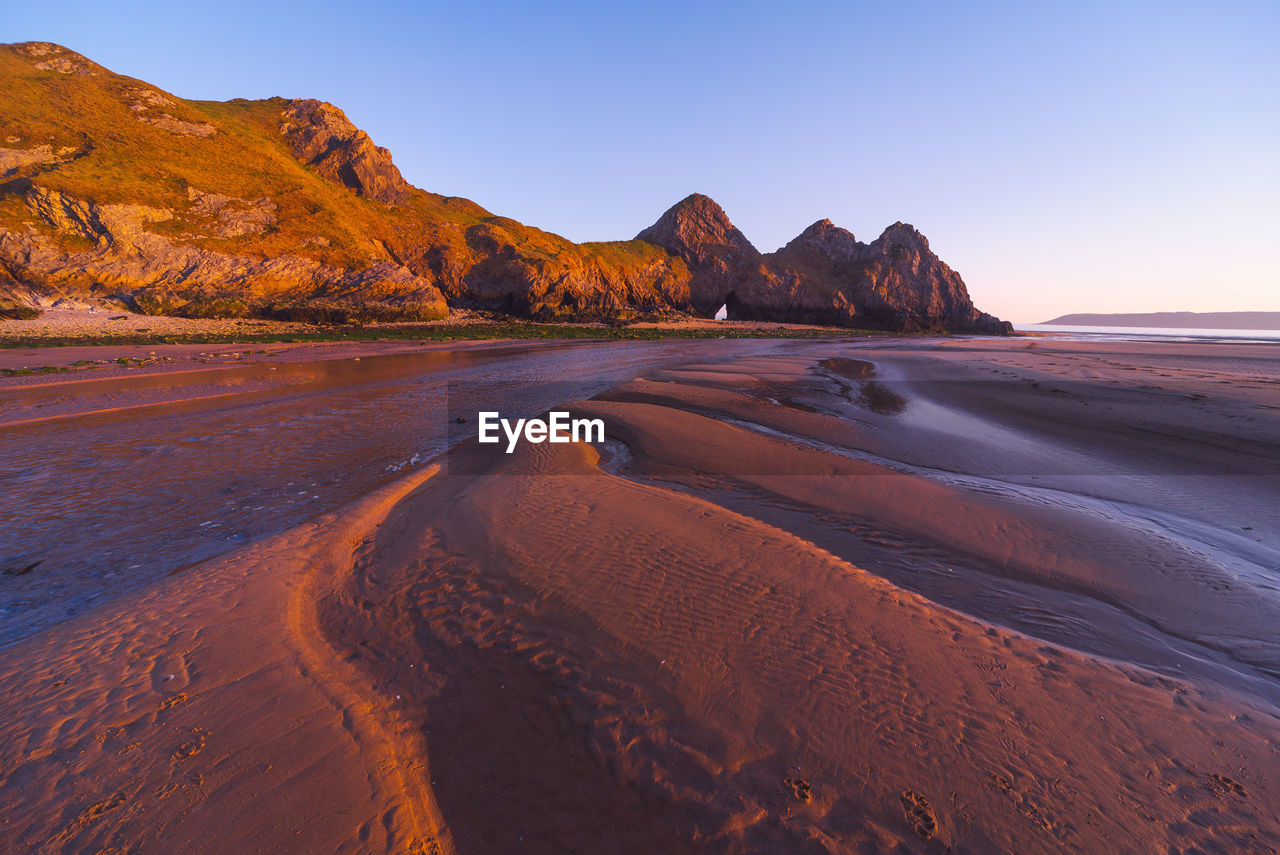 Scenic view of beach against sky during sunset