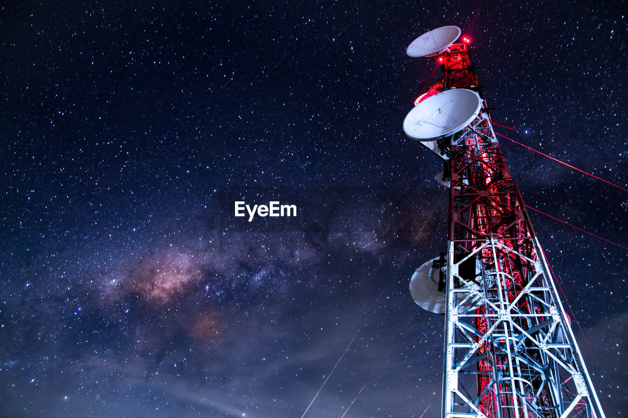 Low angle view of communications tower against sky at night