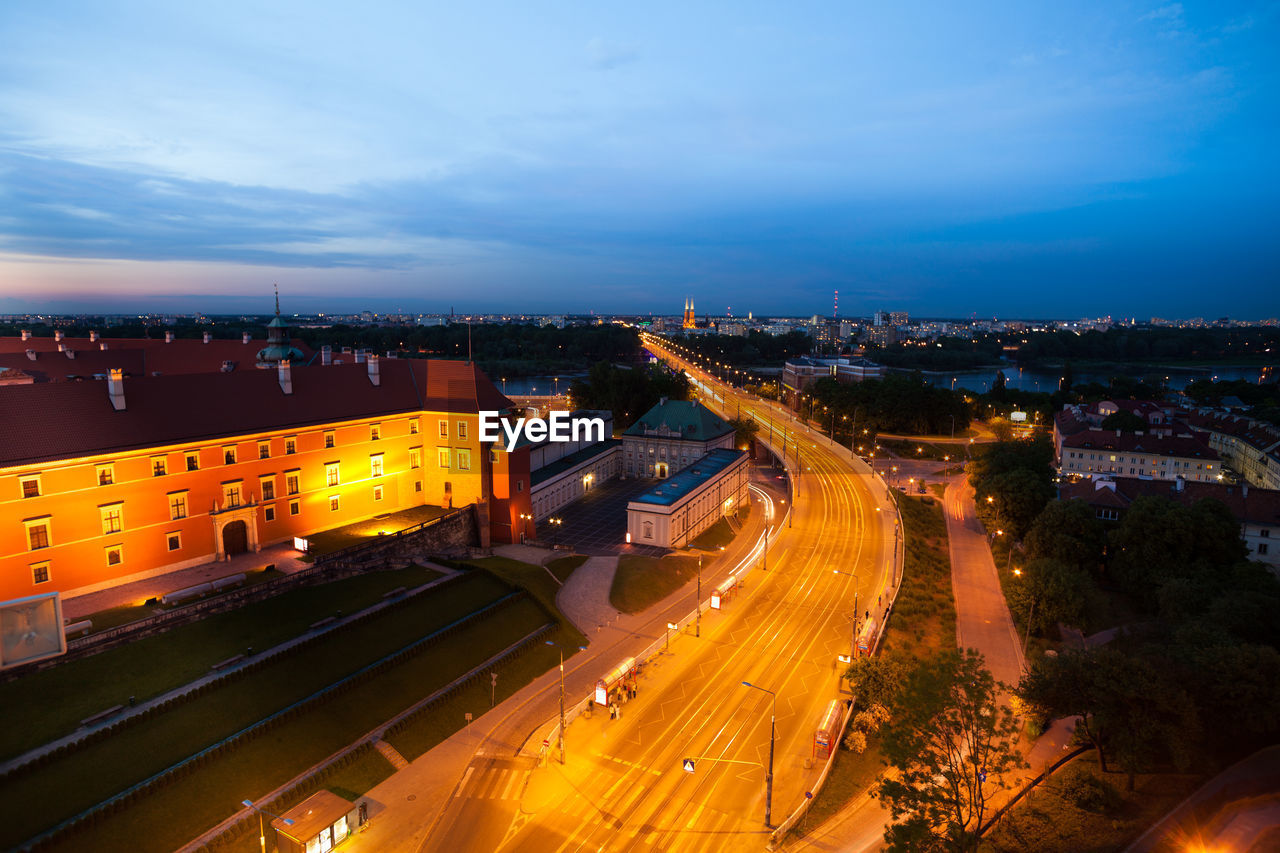 HIGH ANGLE VIEW OF ILLUMINATED CITY STREET AGAINST SKY