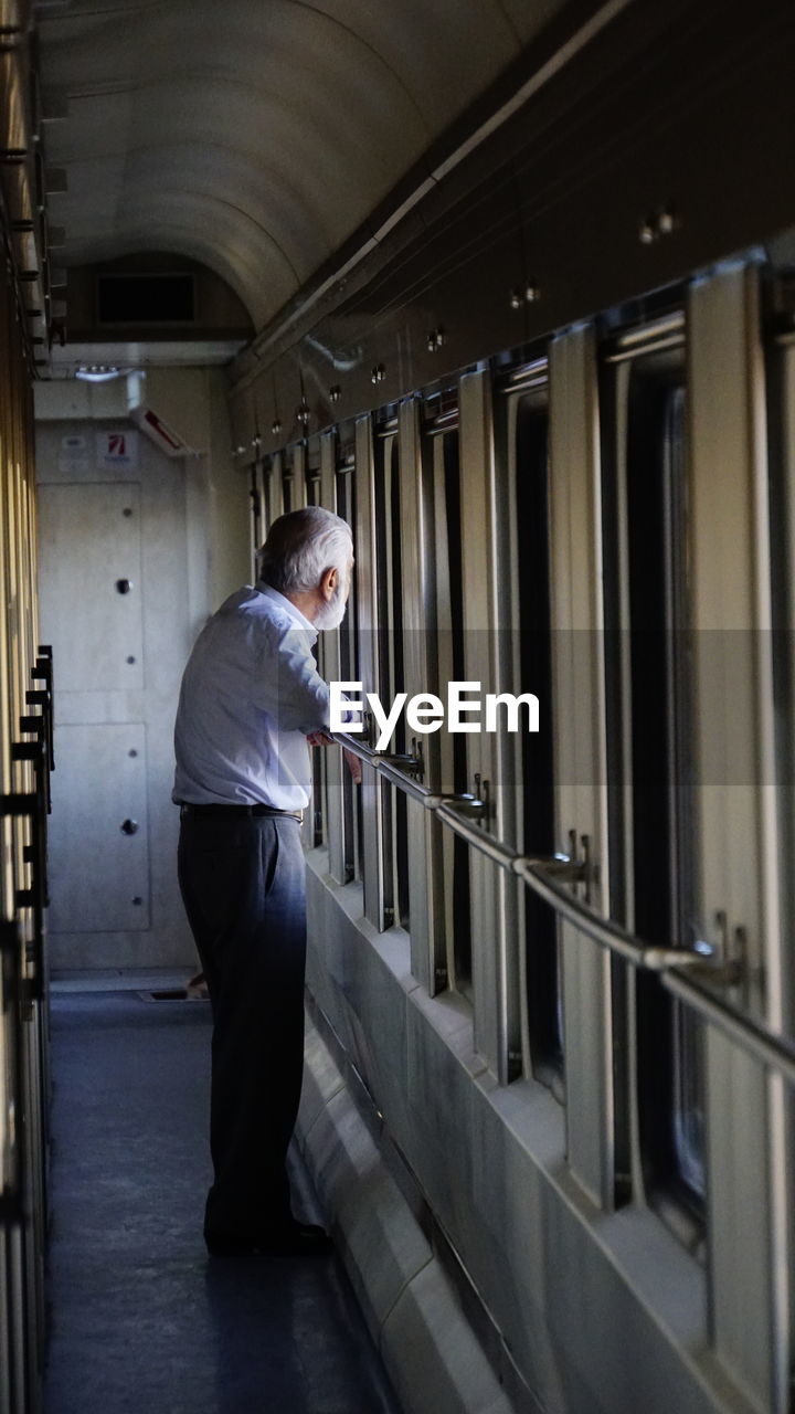 Side view of a man standing in corridor