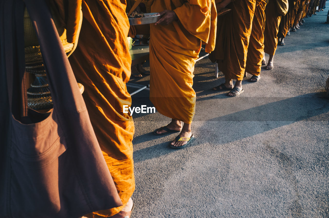 Low section of monks standing outdoors