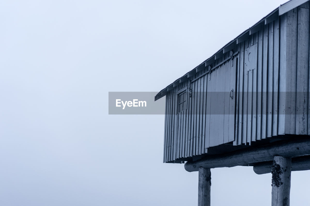 Cropped image of stilt house during foggy weather in winter