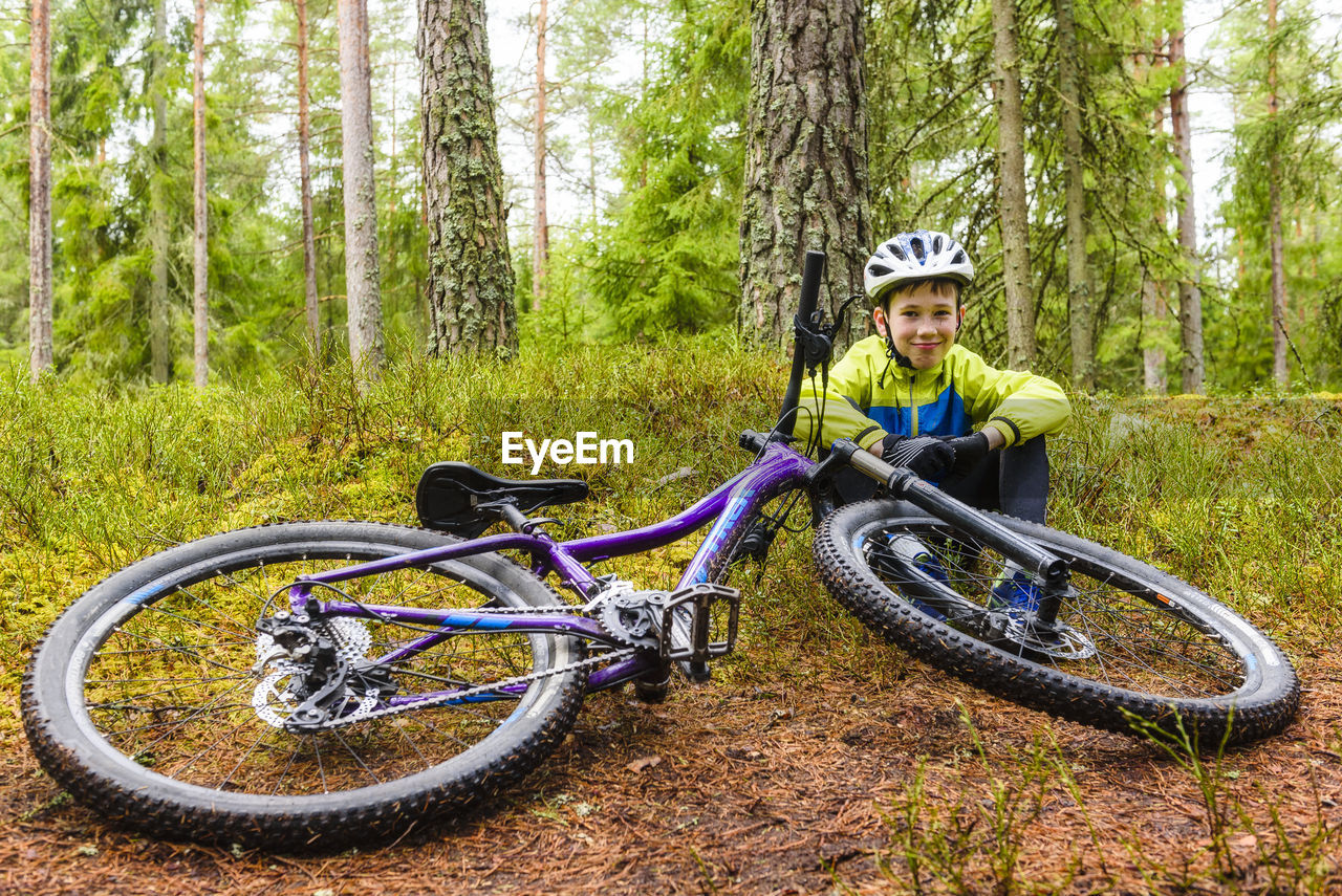 Boy with bike in forest