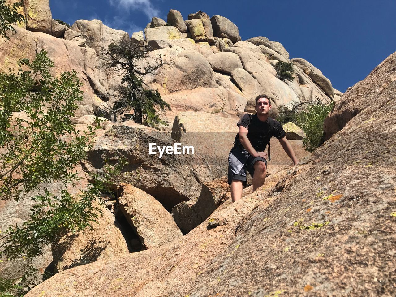 Low angle view of young man standing on mountain