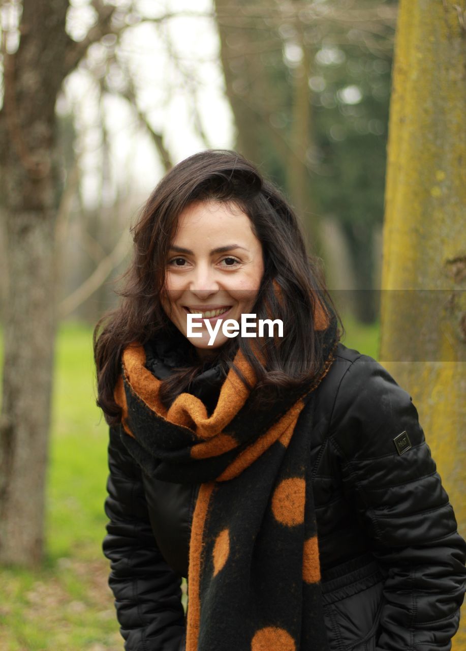 Portrait of smiling woman in forest during winter