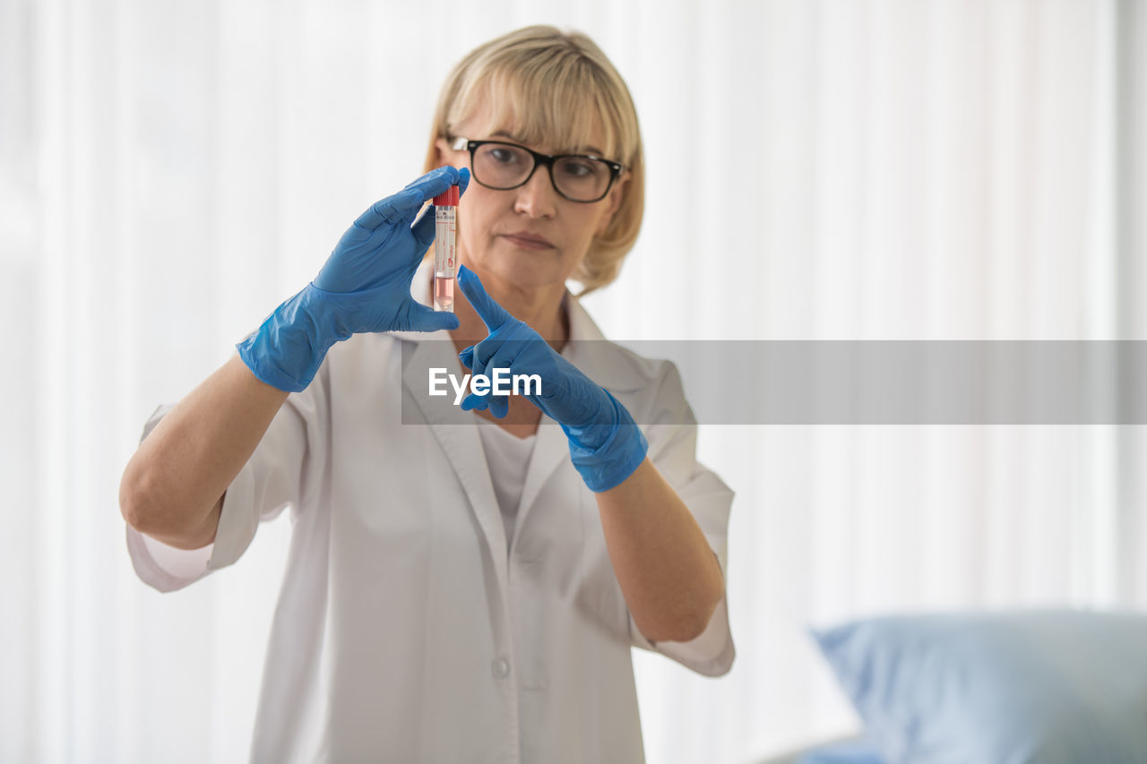 Female doctor examining test tube in hospital