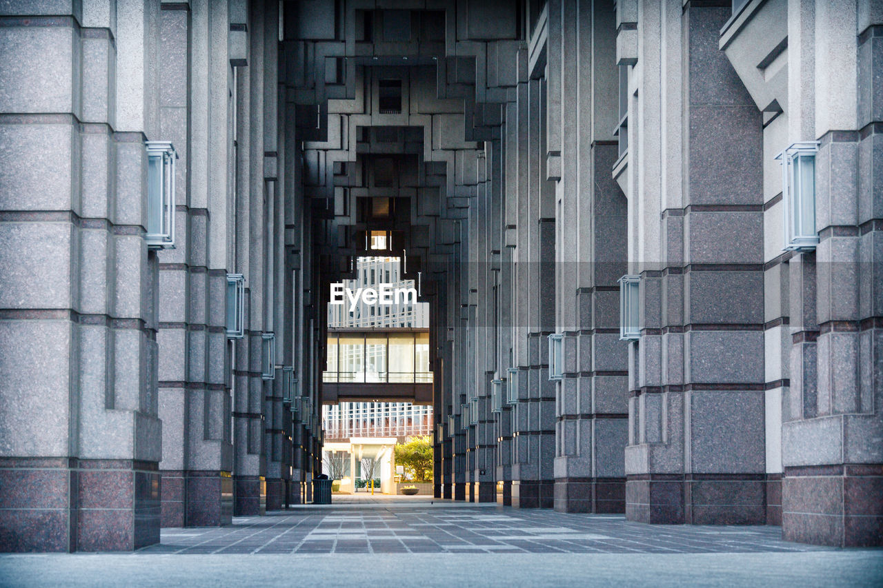 Walkway amidst pillars in modern building