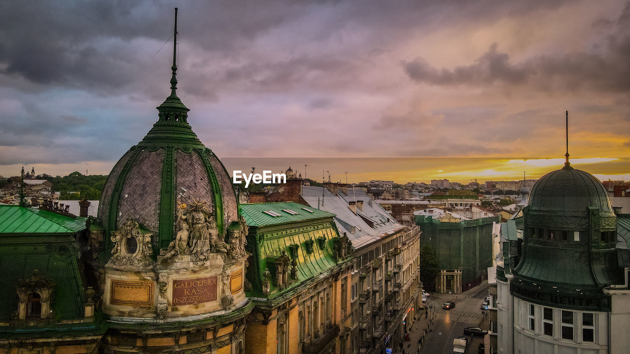 Panoramic view of old buildings in city against sky during sunset