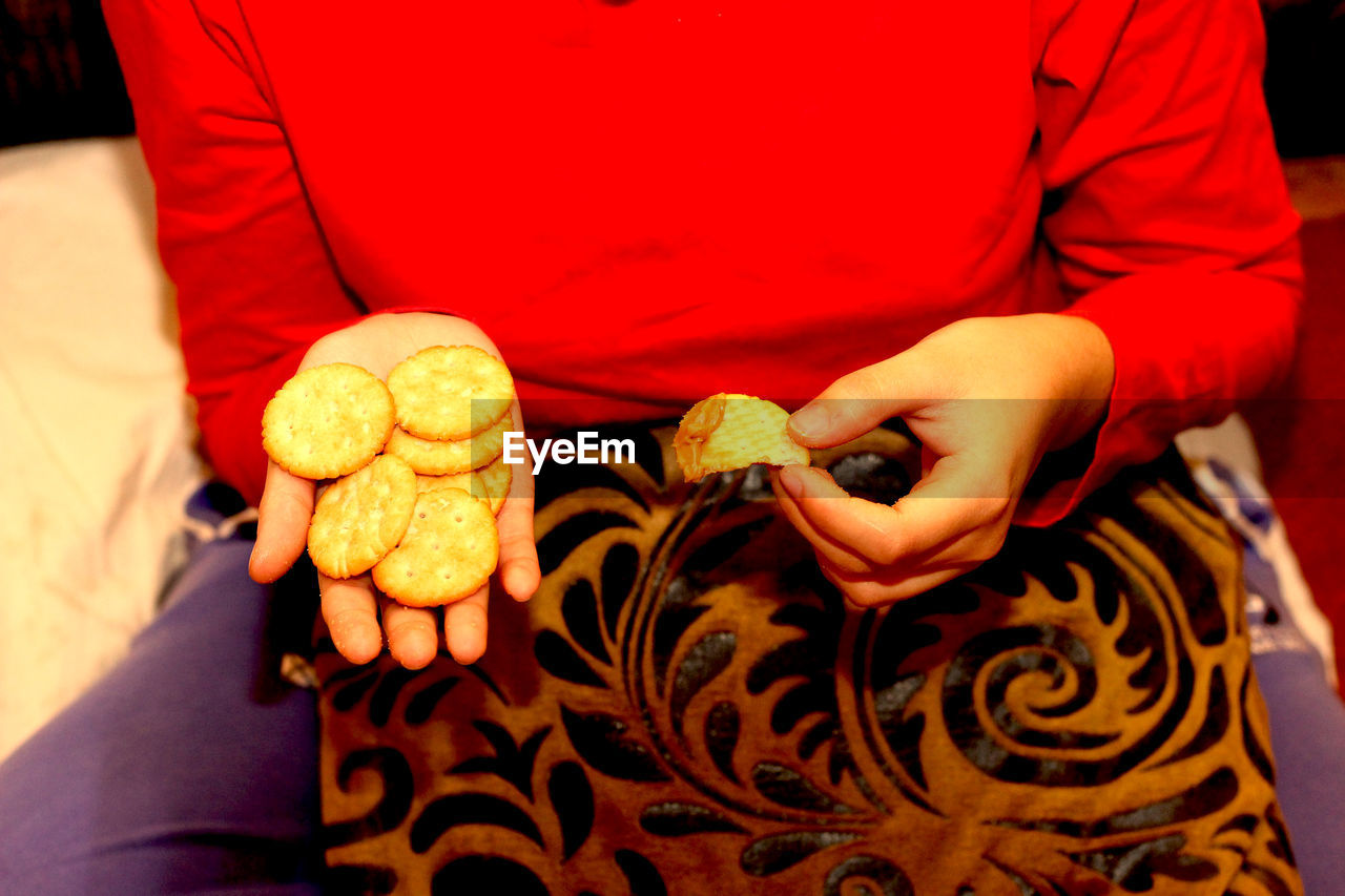 Midsection of woman holding biscuit