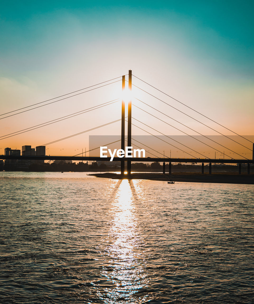 Silhouette bridge over river against sky during sunset