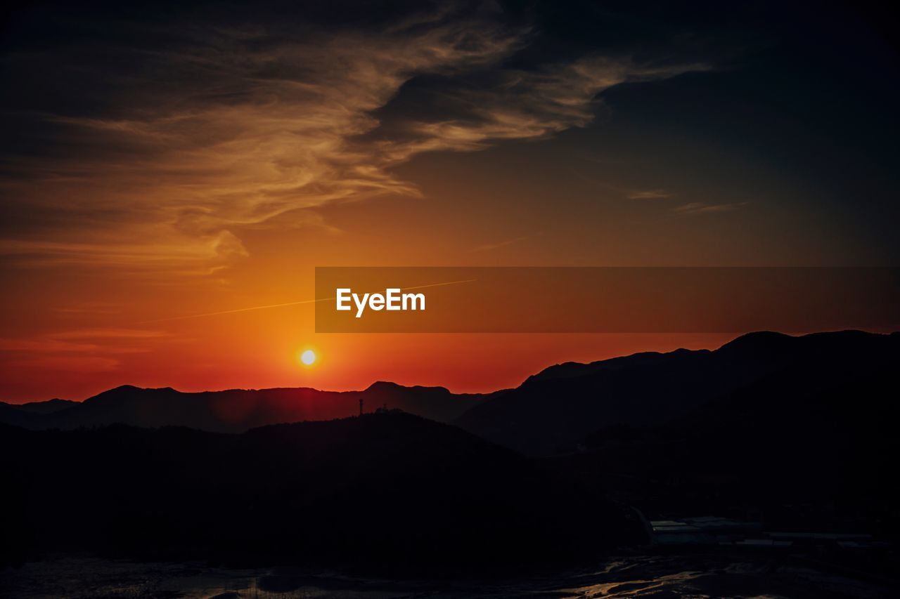 Scenic view of silhouette mountains against sky during sunset