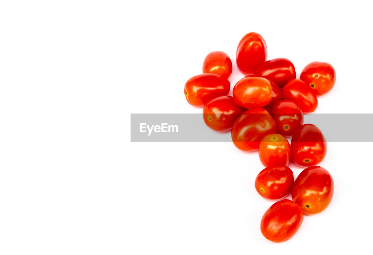 CLOSE-UP OF RED CHERRIES AGAINST WHITE BACKGROUND