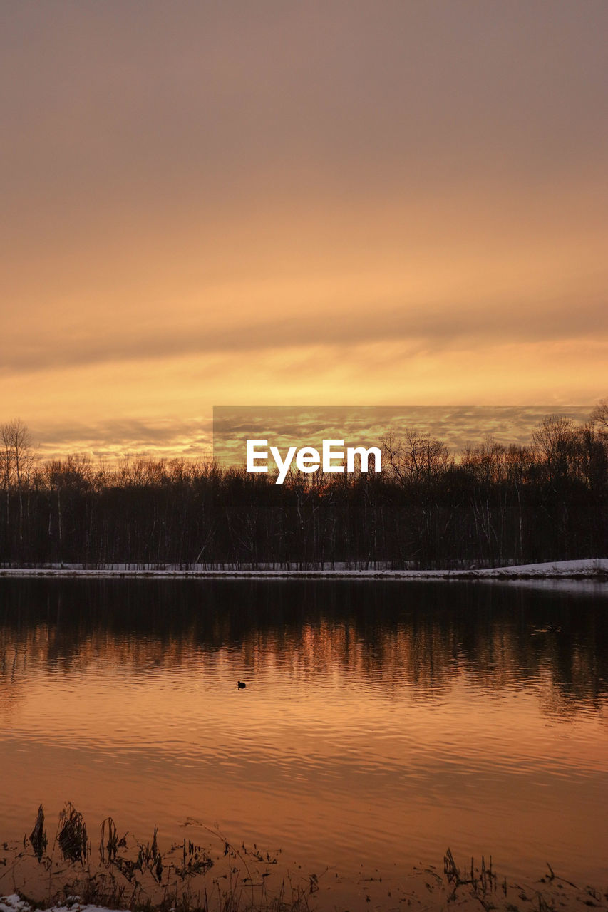 Scenic view of lake against orange sky