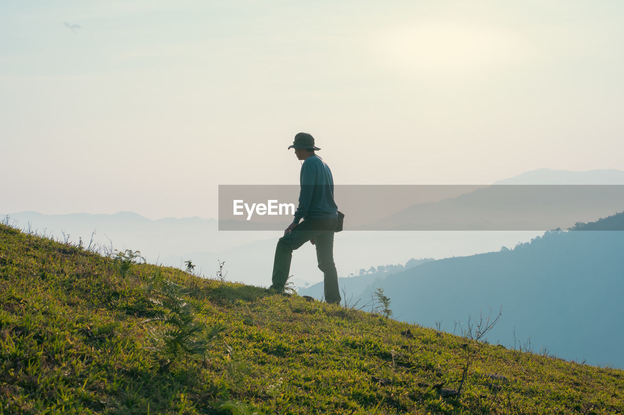 Hiker man relax and yoga exercise with wellbeing and happy feeling on top of mountain