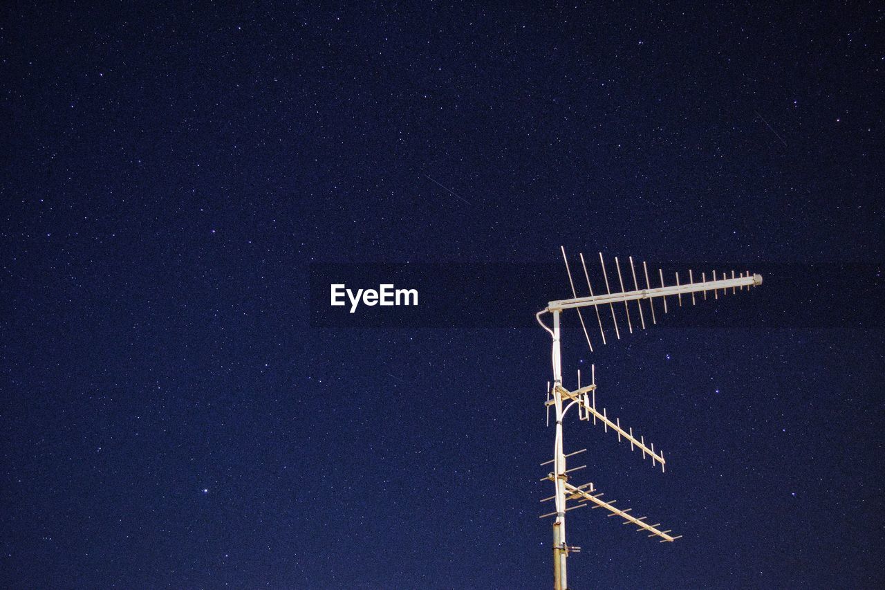 Low angle view of aerial against clear sky at night