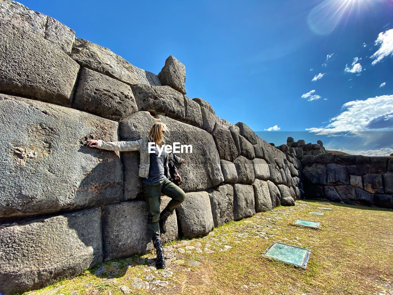 WOMAN ON ROCKS AGAINST THE WALL