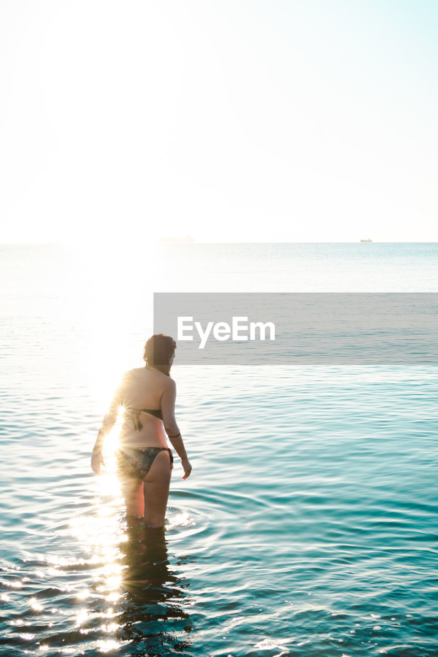 FULL LENGTH OF SHIRTLESS MAN ON SEA AGAINST SKY