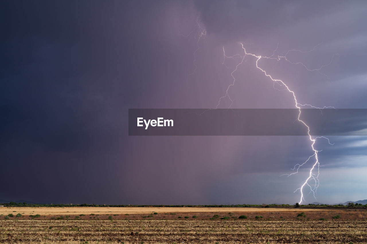 Thunderstorm lightning strike with dark clouds and rain near tucson, arizona