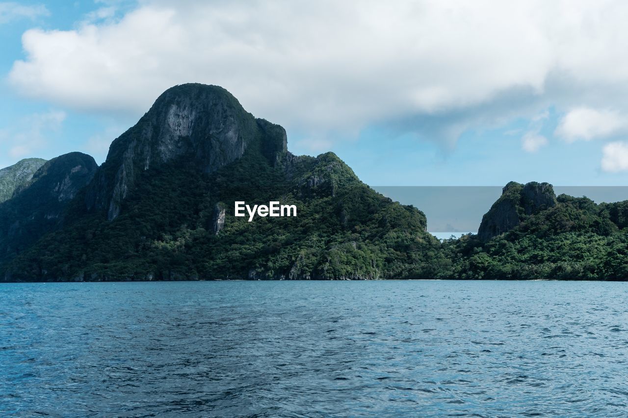 Scenic view of sea and mountains against sky