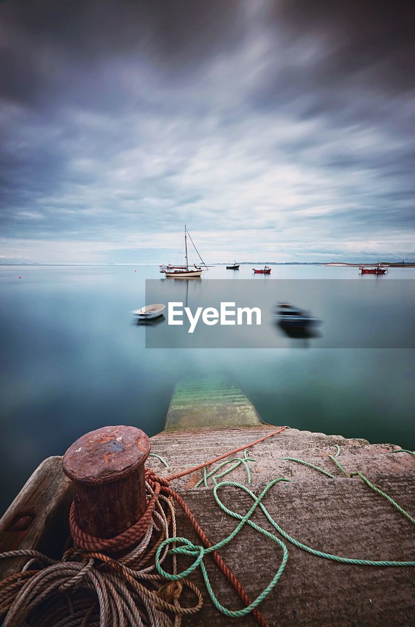 Boats moored in sea against sky