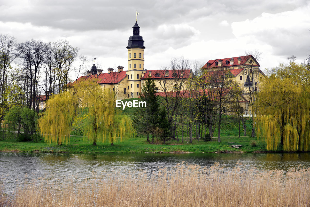 BUILDING BY LAKE AGAINST SKY