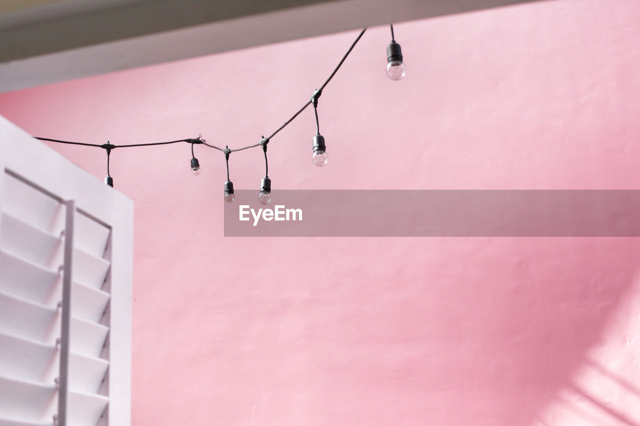 Low angle view of lighting equipment hanging on wall