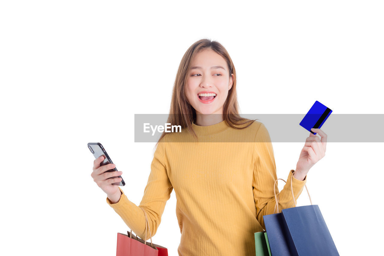 SMILING YOUNG MAN USING SMART PHONE