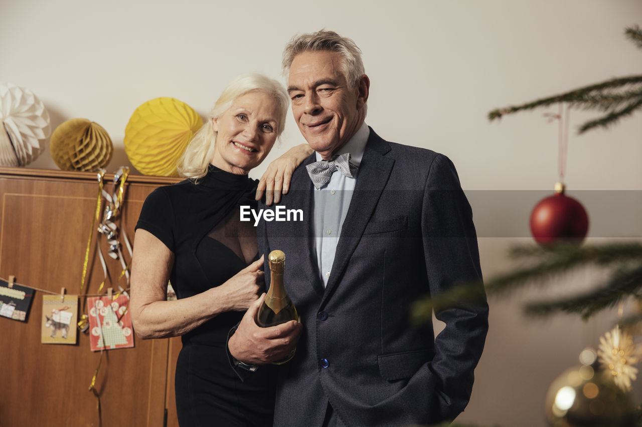 Senior couple holding bottle of champagne on new yera's eve