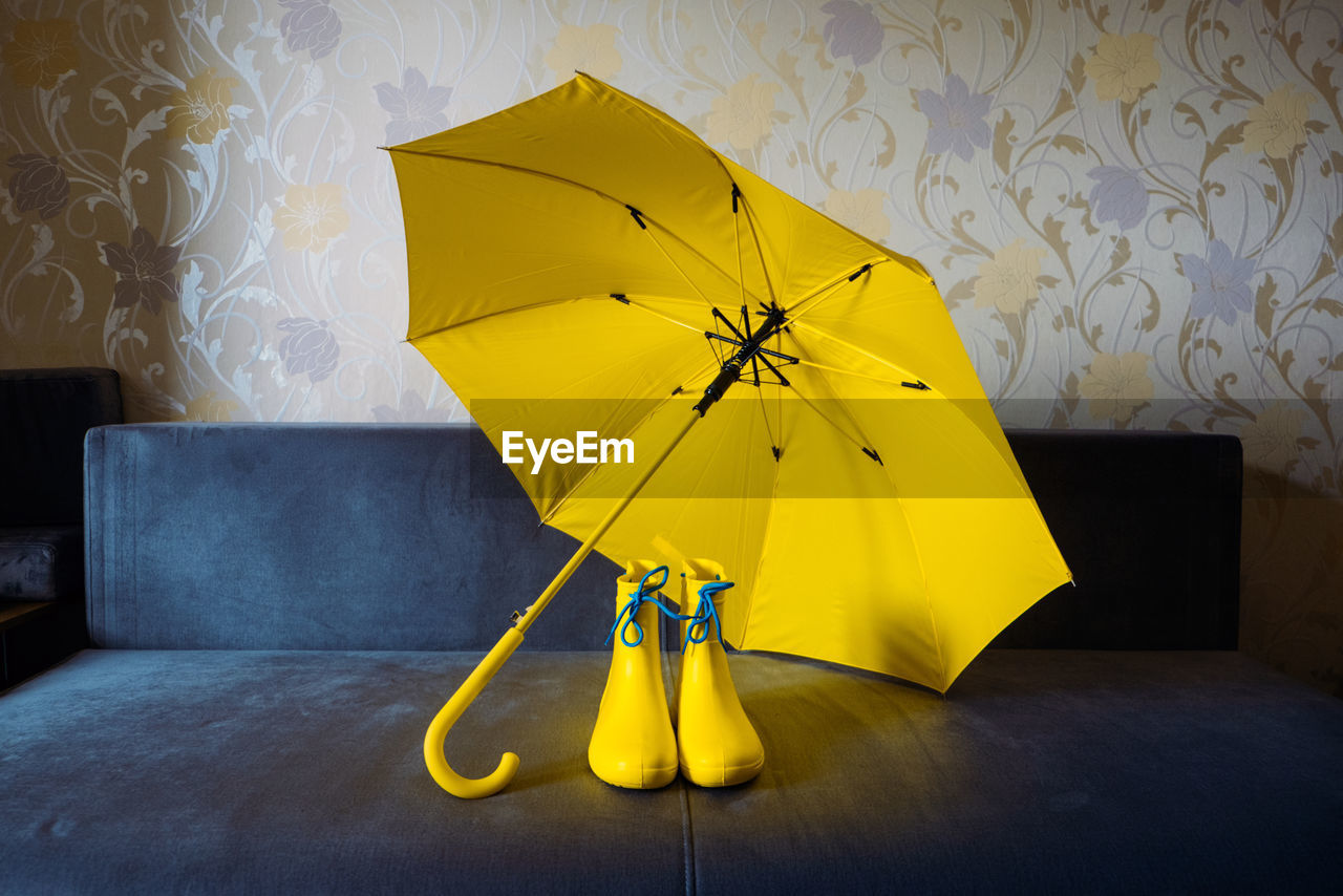 Yellow umbrella on wet table at home