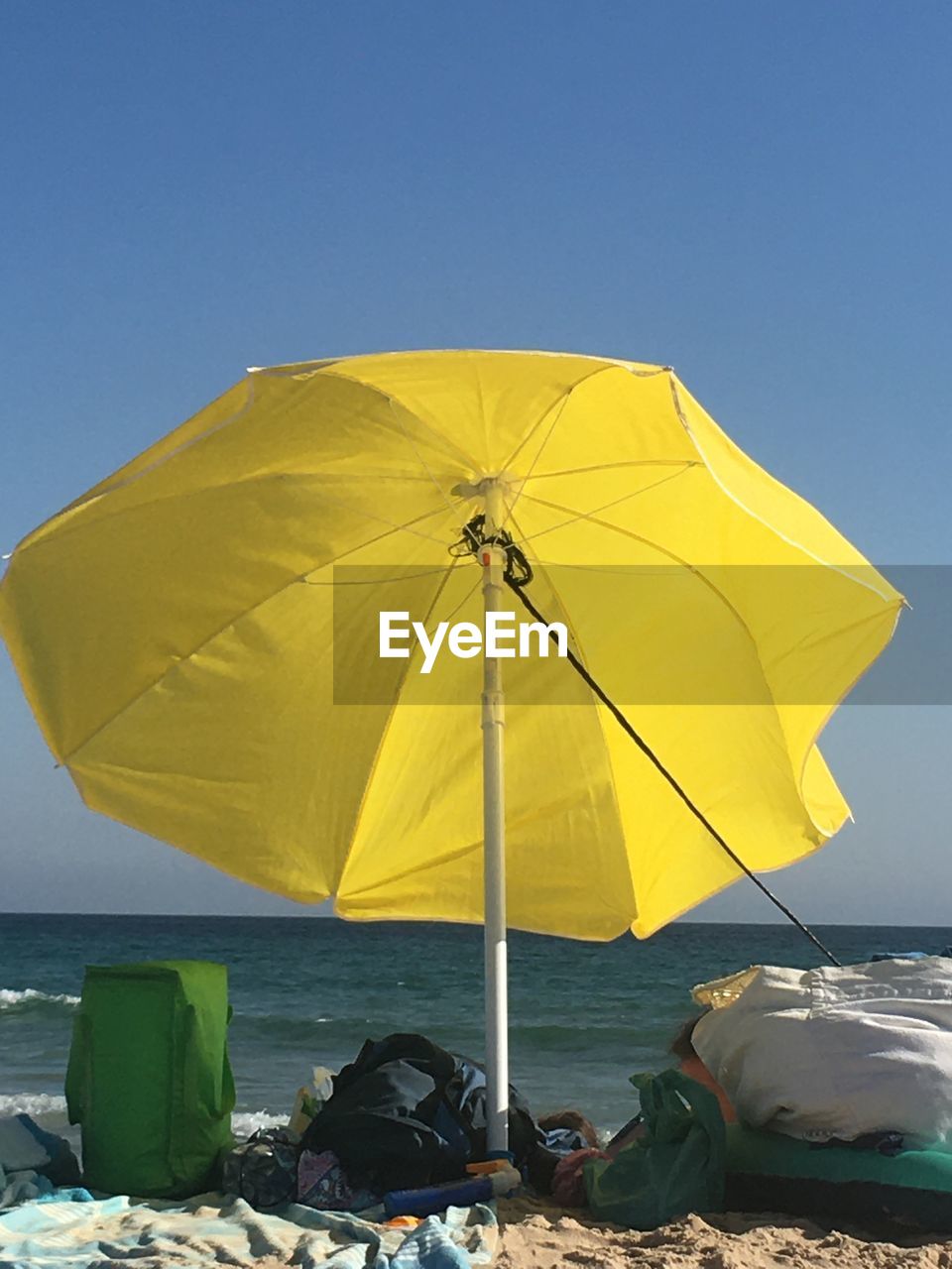 Yellow umbrella on beach against clear sky