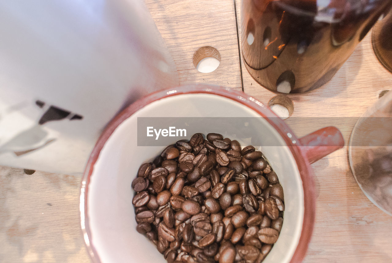 High angle view of roasted coffee beans in cup on table