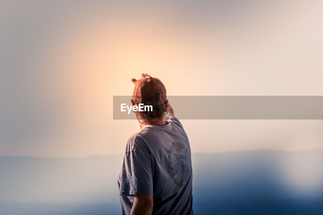 Rear view of woman standing against sea