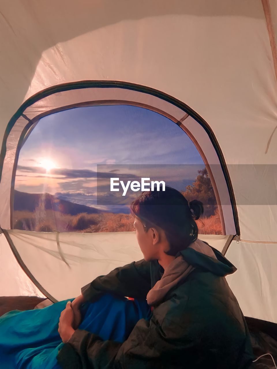 BOY LOOKING THROUGH WINDOW AGAINST SKY