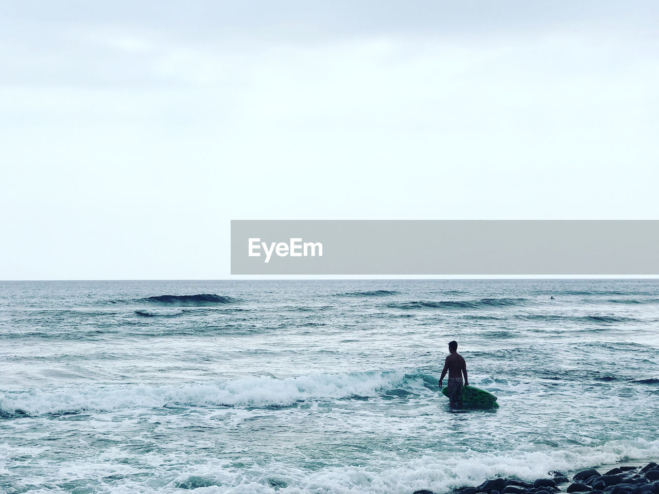 MAN ON SHORE AGAINST SKY