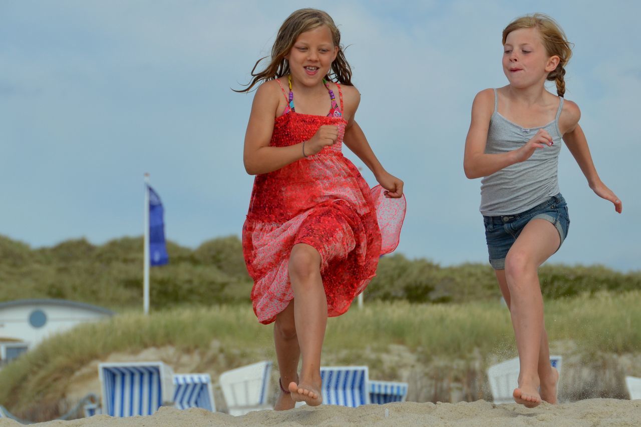 Two girls running on the beach
