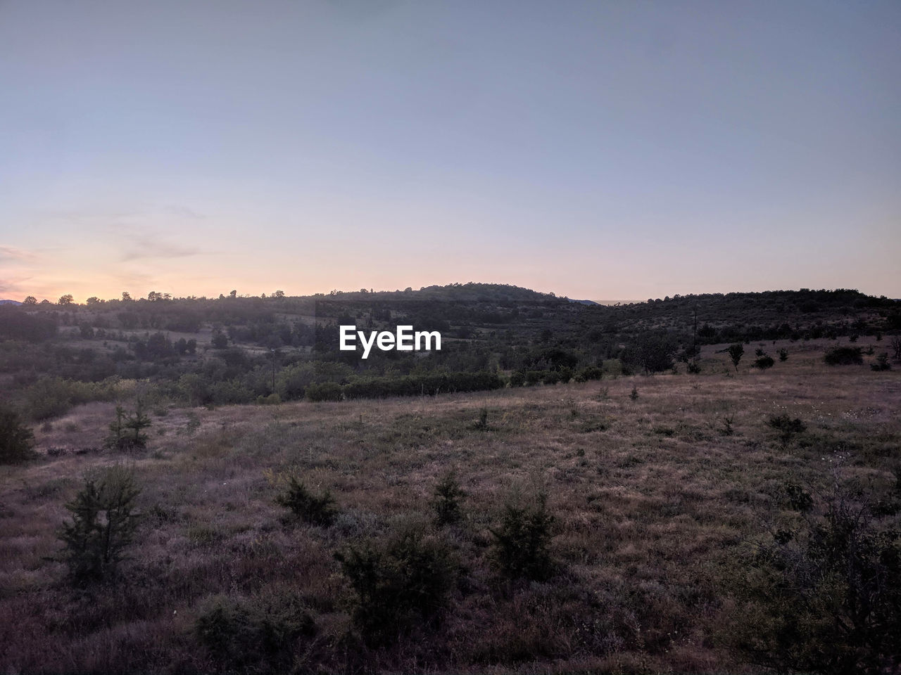 SCENIC VIEW OF LANDSCAPE AGAINST CLEAR SKY DURING SUNSET