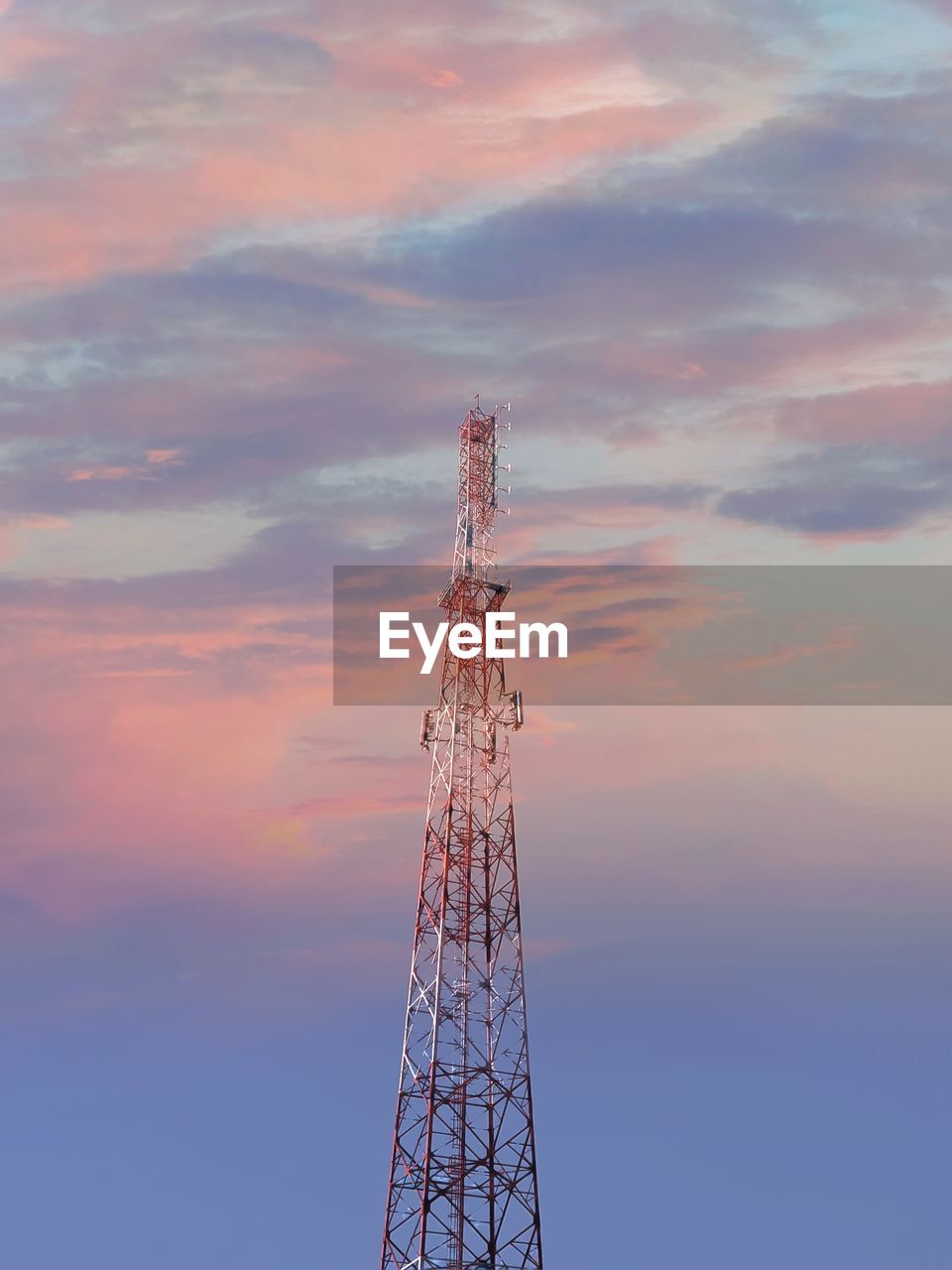 Low angle view of electricity pylon against sky during sunset