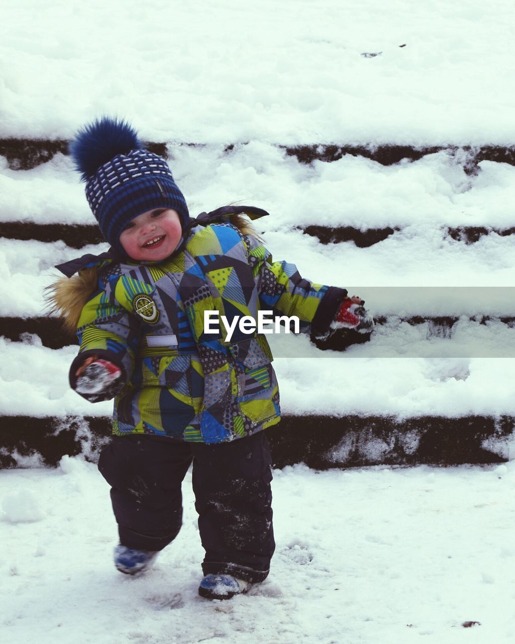 PORTRAIT OF CUTE BOY STANDING IN SNOW