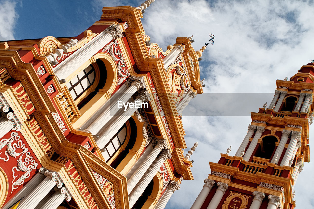 LOW ANGLE VIEW OF ORNATE BUILDING AGAINST CLOUDY SKY