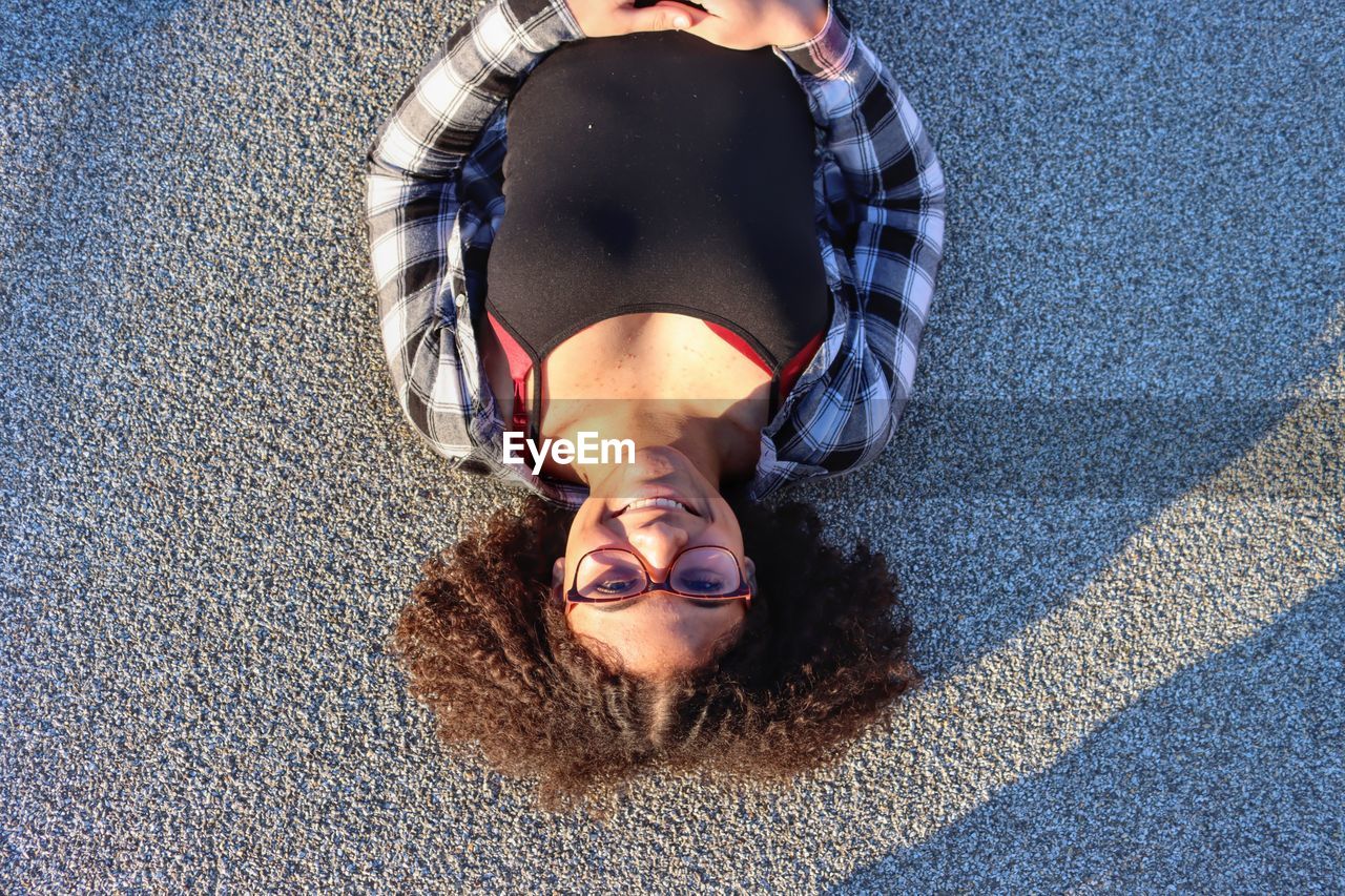 HIGH ANGLE PORTRAIT OF SMILING WOMAN LYING DOWN ON MAN