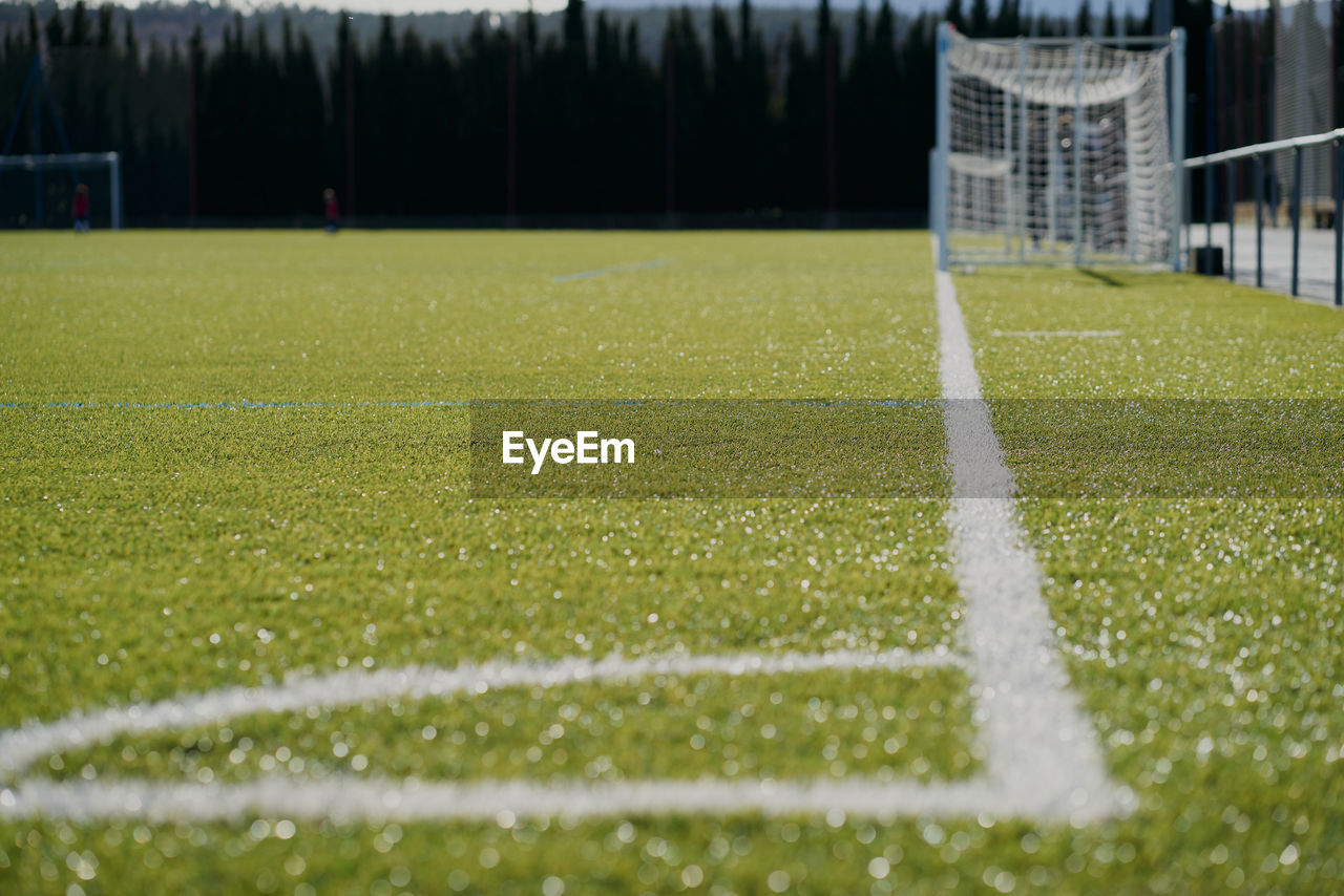 The white line in the football corner on the green field with the goal