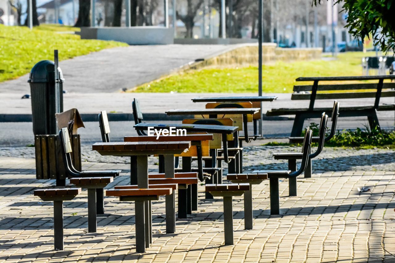 Empty chairs and table on footpath