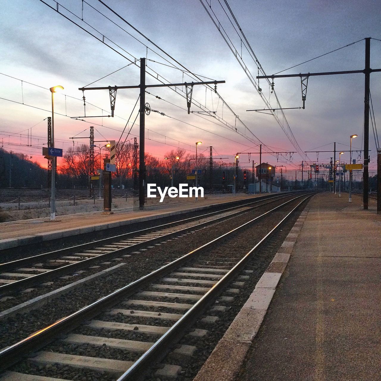 RAILROAD TRACKS AGAINST SKY AT SUNSET