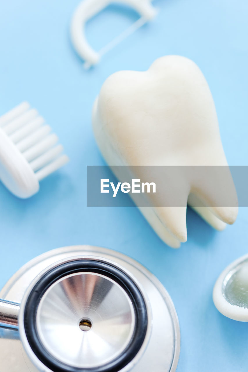 Close-up high angle view of dental equipment over blue background