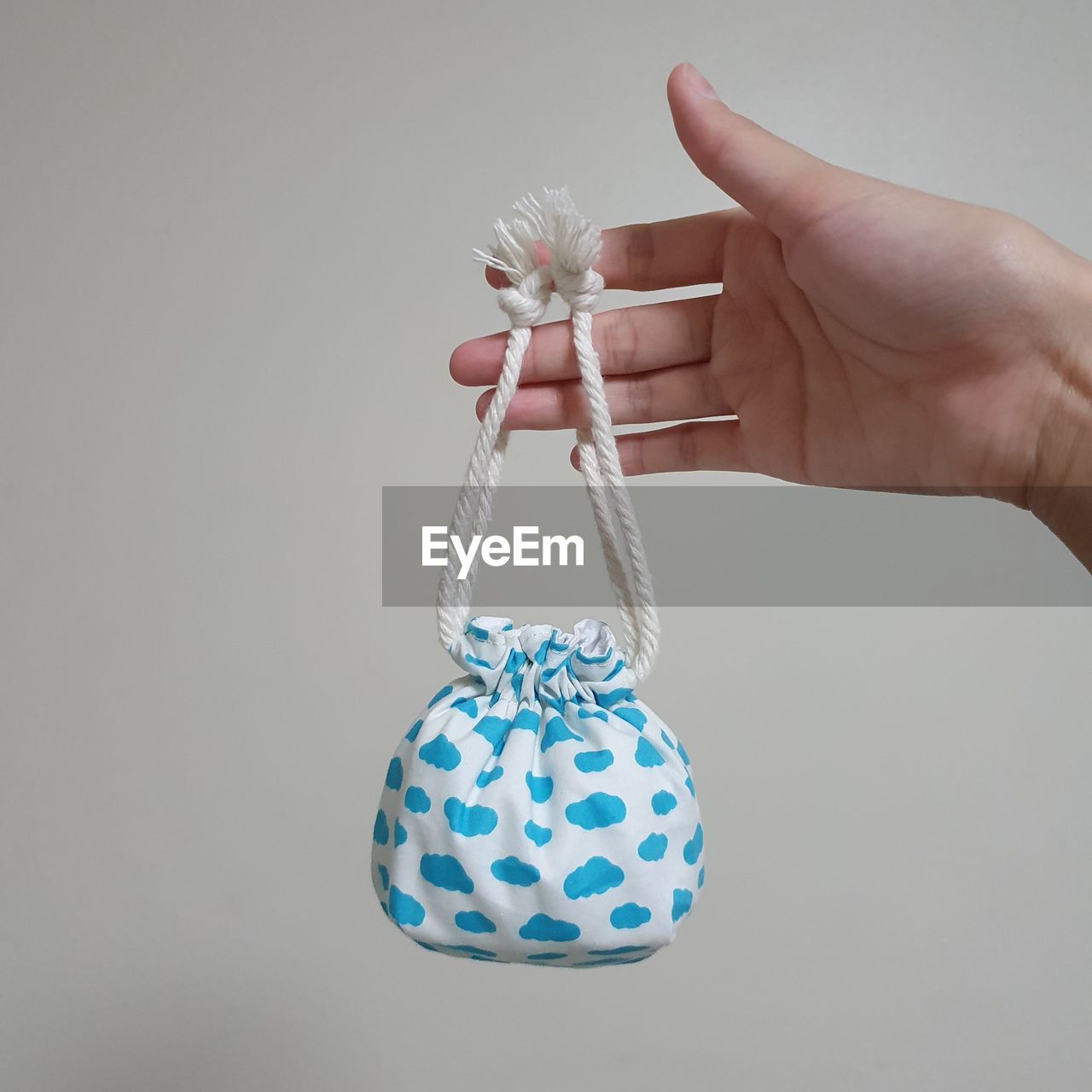 CLOSE-UP OF HAND HOLDING UMBRELLA