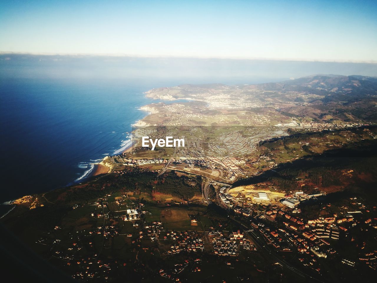 AERIAL VIEW OF SEA BY AIRPLANE AGAINST SKY DURING SUNSET