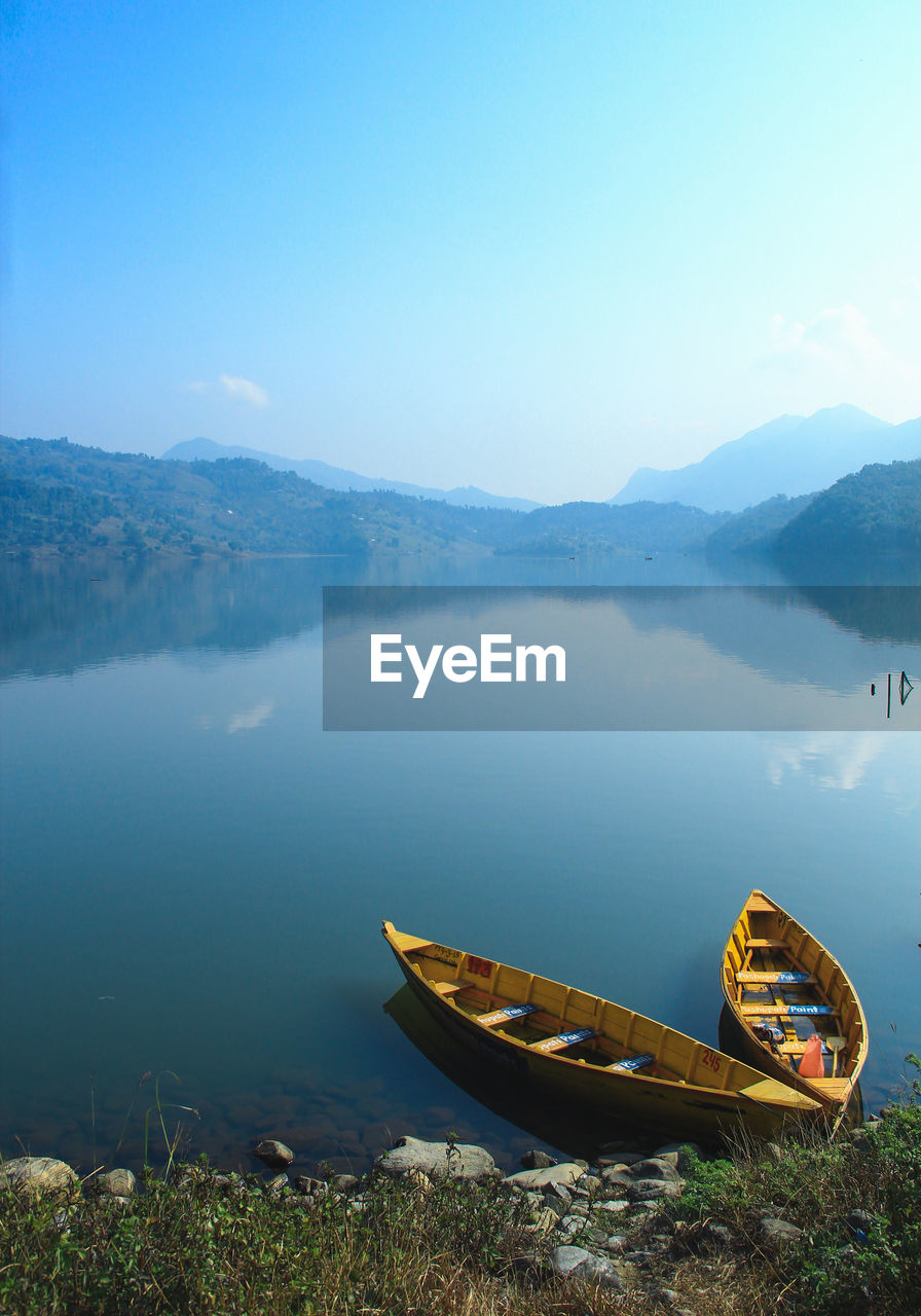 Scenic view of lake by mountains against sky