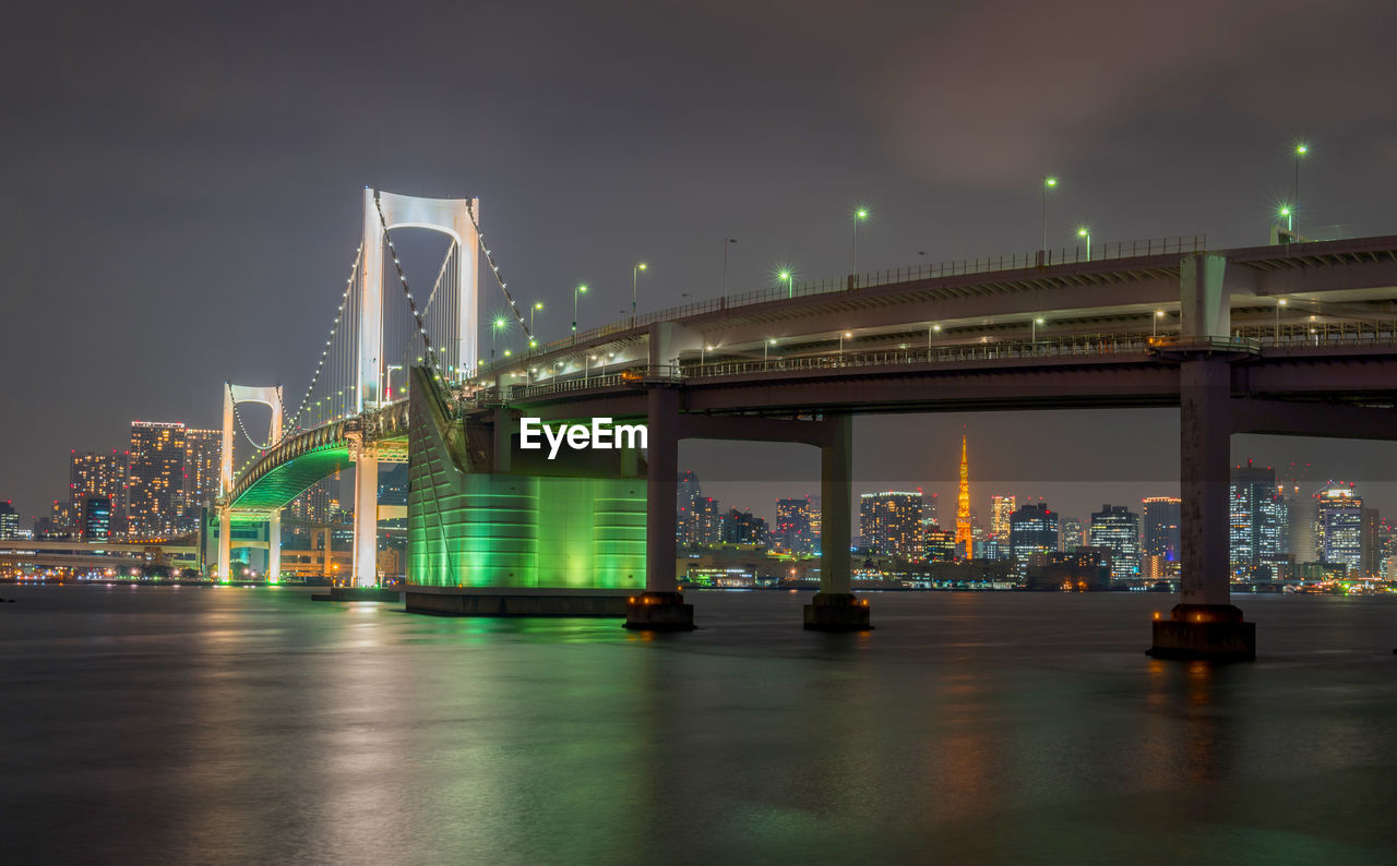 View of bridge over river at night