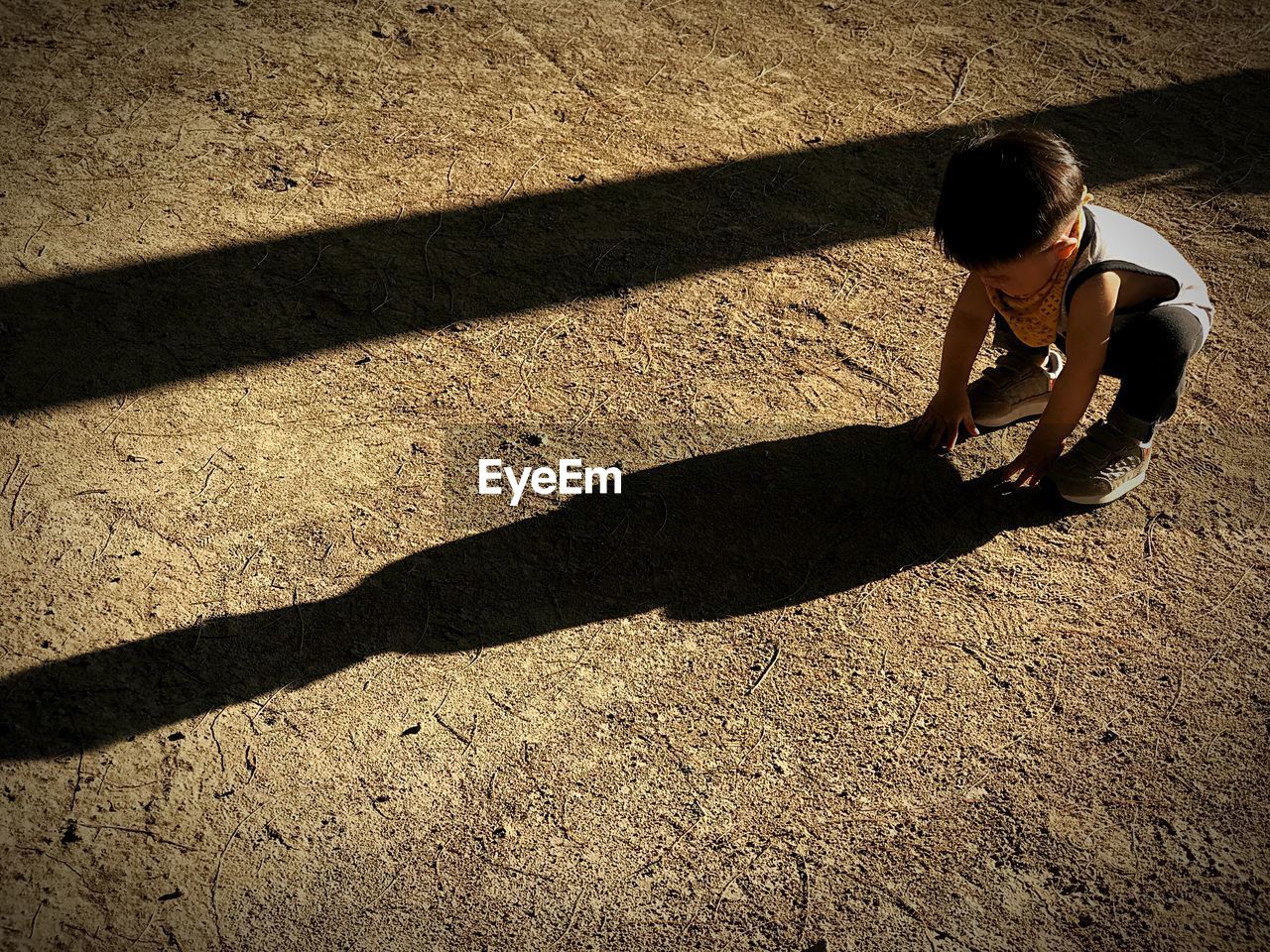 High angle view of baby boy crouching on field